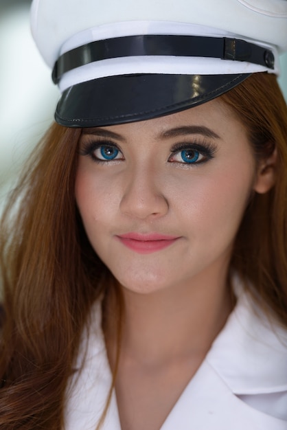 Retrato de uma jovem bonita da marinha asiática, vestindo uniforme dentro de casa