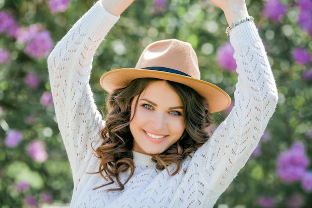 Retrato de uma jovem bonita em um parque florido lilás.