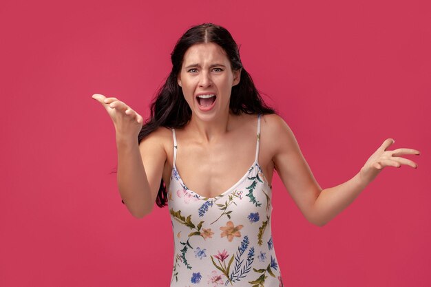 Retrato de uma jovem bonita em um vestido leve de pé sobre um fundo rosa em pessoas do estúdio desde ...