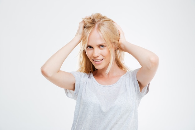 Retrato de uma jovem bonita feliz com cabelo loiro sobre uma parede branca