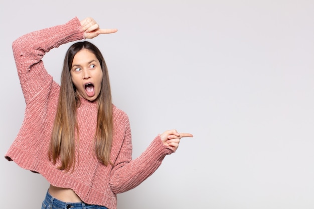 Foto retrato de uma jovem bonita mostrando algo