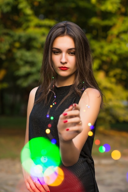 Retrato de uma jovem bonita segurando uma guirlanda na rua da cidade