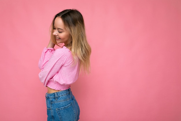 Retrato de uma jovem bonita sorridente hippie loira com blusa na moda rosa corte superior sexy