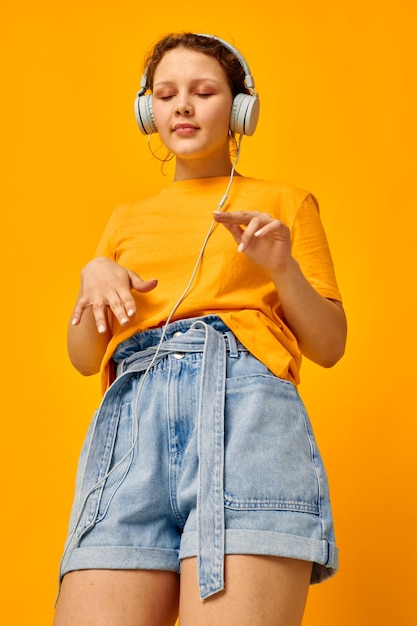 Retrato de uma jovem camiseta amarela fones de ouvido entretenimento música diversão vista cortada inalterada