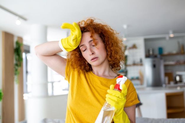Retrato de uma jovem cansada com luvas de borracha descansando após a limpeza de um apartamento Conceito de limpeza doméstica