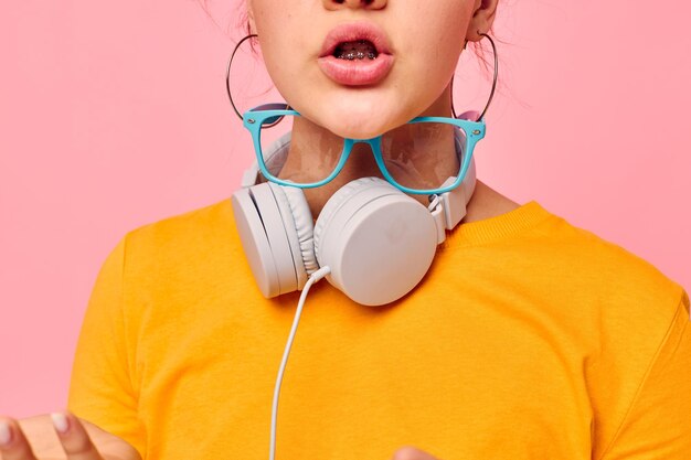 Retrato de uma jovem careta fones de ouvido música tecnologia de entretenimento fundo rosa inalterado