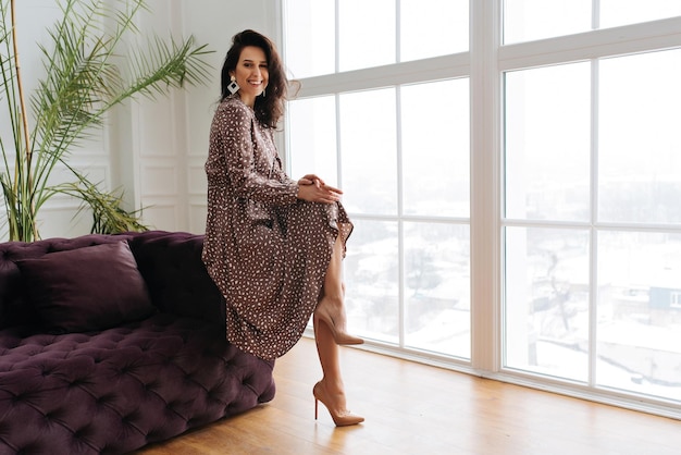 Foto retrato de uma jovem caucasiana com maquiagem natural leve em vestido floral sentado