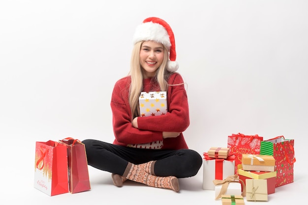 Retrato de uma jovem caucasiana feliz com chapéu de papai noel com caixa de presente