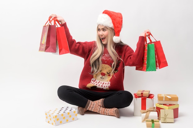 Retrato de uma jovem caucasiana feliz com chapéu de papai noel com presente