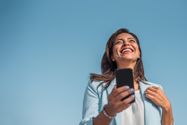 Retrato de uma jovem chinesa feliz com seu celular Copie o espaço