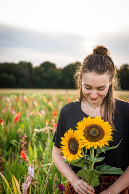 Foto retrato de uma jovem com flores amarelas no campo