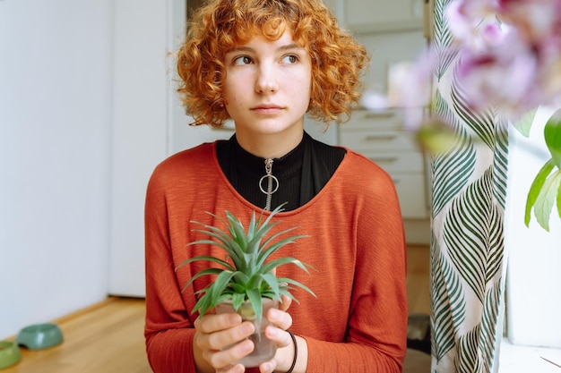 Retrato de uma jovem com mudas de abacaxi decorativas de planta doméstica