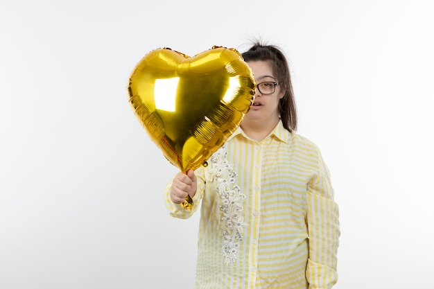 Retrato de uma jovem com síndrome de Down segurando um balão de ar em forma de coração