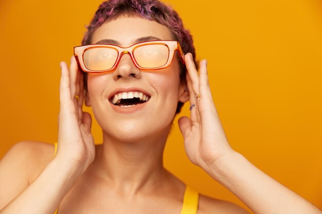 Retrato de uma jovem com um corte de cabelo curto e cabelo colorido em um fundo de estúdio laranja Foto de alta qualidade