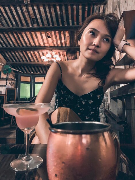 Foto retrato de uma jovem com uma bebida em um restaurante