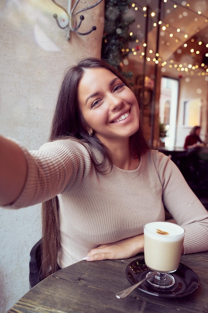 Foto retrato de uma jovem com uma xícara de café na mesa