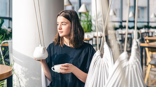 Retrato de uma jovem com uma xícara de chá em um café