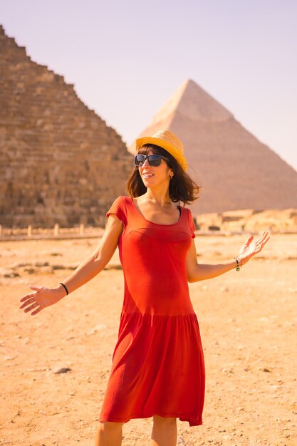 Retrato de uma jovem com vestido vermelho na pirâmide de Quéops, a maior pirâmide. As pirâmides de Gizé, o monumento funerário mais antigo do mundo. Na cidade do Cairo, Egito