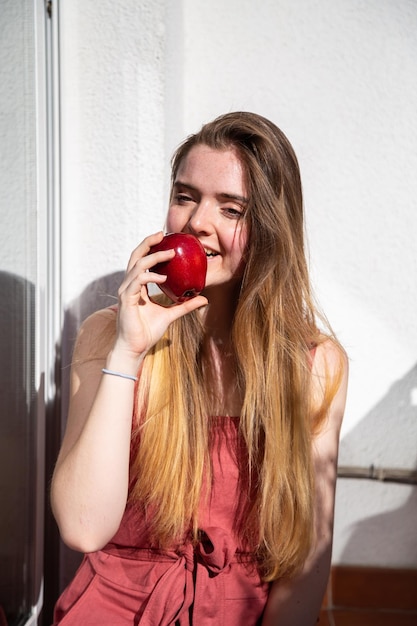 Foto retrato de uma jovem comendo maçã