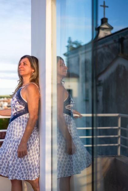 Foto retrato de uma jovem de pé contra a janela