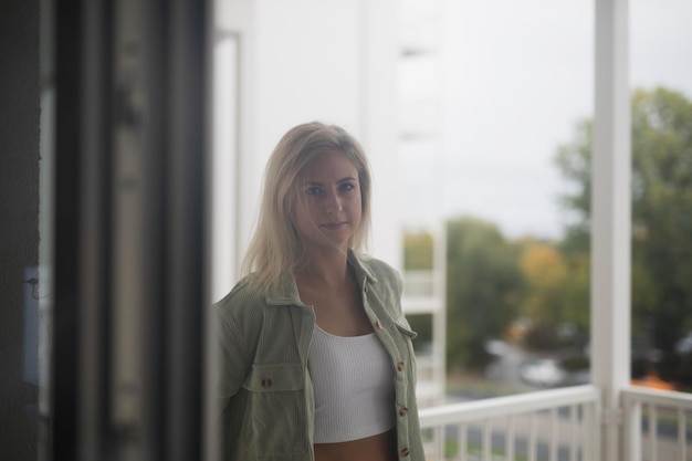 Foto retrato de uma jovem de pé contra a janela
