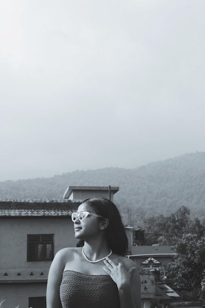 Foto retrato de uma jovem de pé contra a montanha