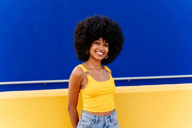 Foto retrato de uma jovem de pé contra a parede