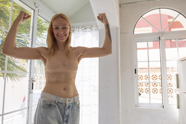Foto retrato de uma jovem de pé contra a parede