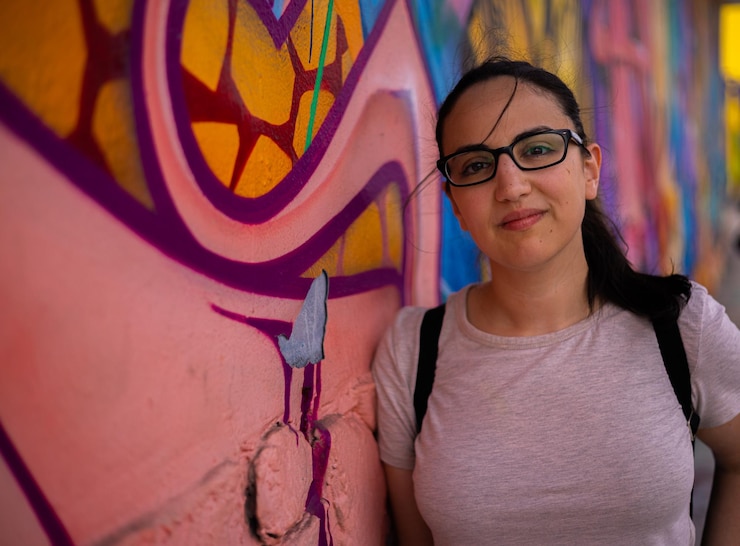 Foto retrato de uma jovem de pé contra a parede