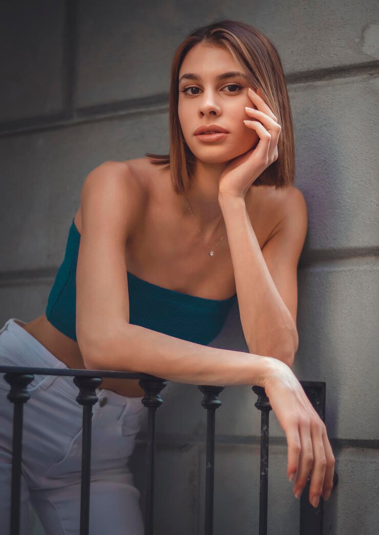 Foto retrato de uma jovem de pé contra a parede