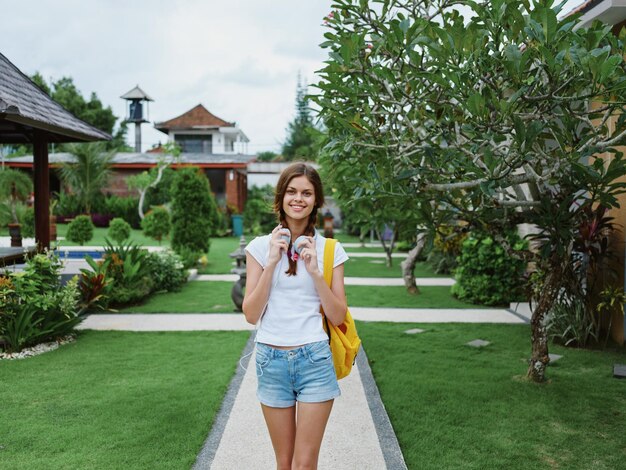 Foto retrato de uma jovem de pé contra as árvores