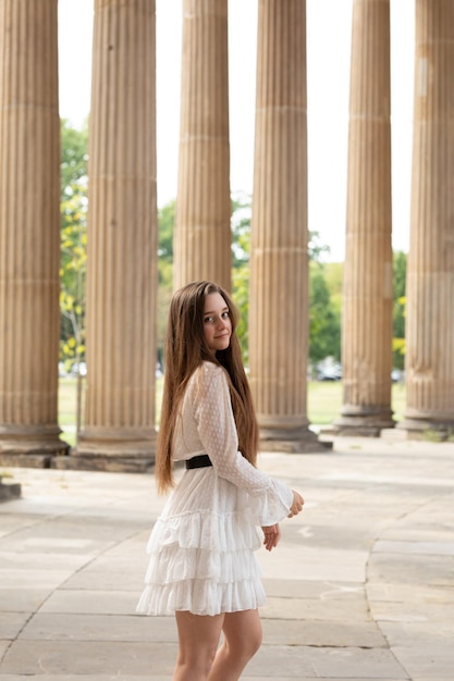 Foto retrato de uma jovem de pé contra colunas