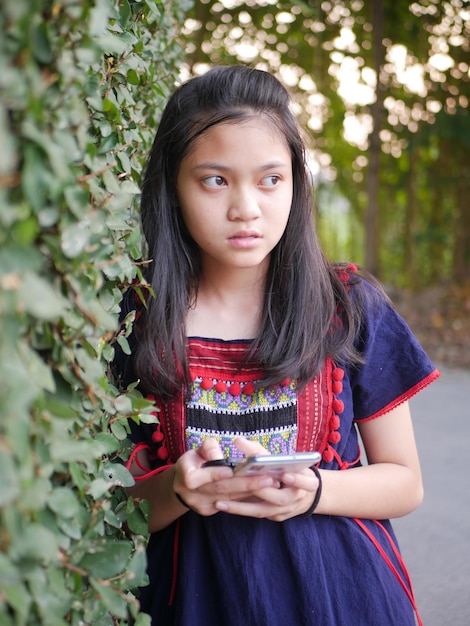 Foto retrato de uma jovem de pé contra plantas