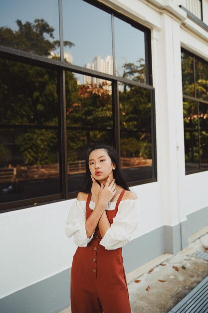 Foto retrato de uma jovem de pé contra um edifício