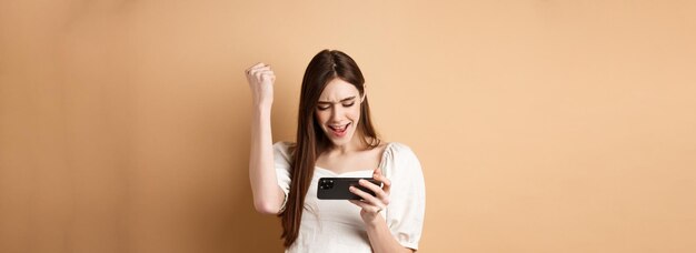 Foto retrato de uma jovem de pé contra um fundo amarelo