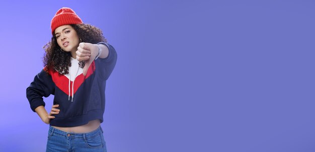 Foto retrato de uma jovem de pé contra um fundo azul