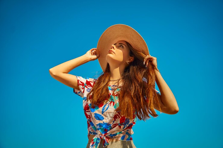 Foto retrato de uma jovem de pé contra um fundo azul