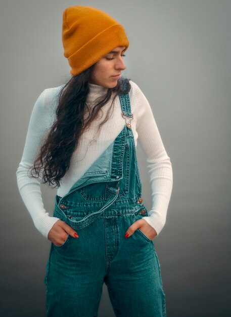 Foto retrato de uma jovem de pé contra um fundo azul