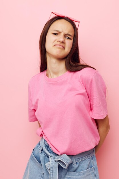 Foto retrato de uma jovem de pé contra um fundo rosa