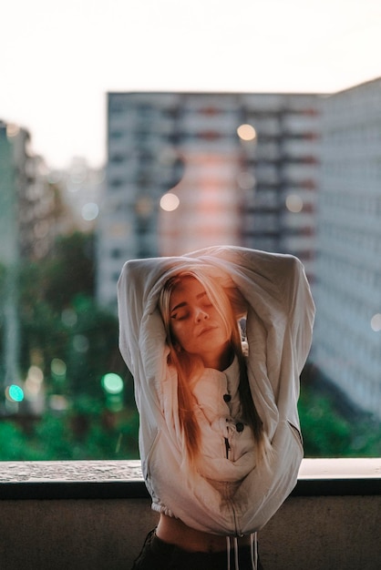 Foto retrato de uma jovem de pé contra uma estrutura construída