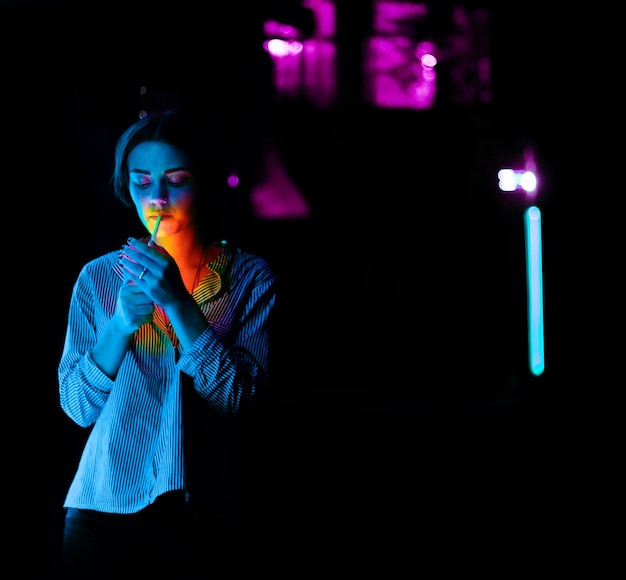 Foto retrato de uma jovem de pé contra uma rua iluminada à noite