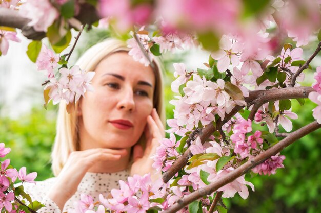 Foto retrato de uma jovem de pé junto a flores