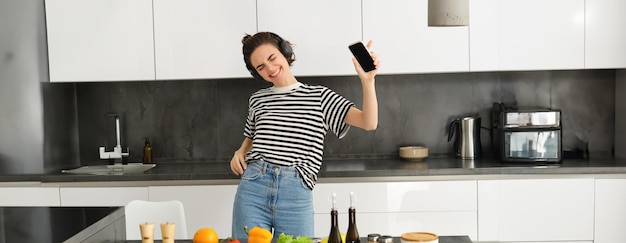 Foto retrato de uma jovem de pé na cozinha