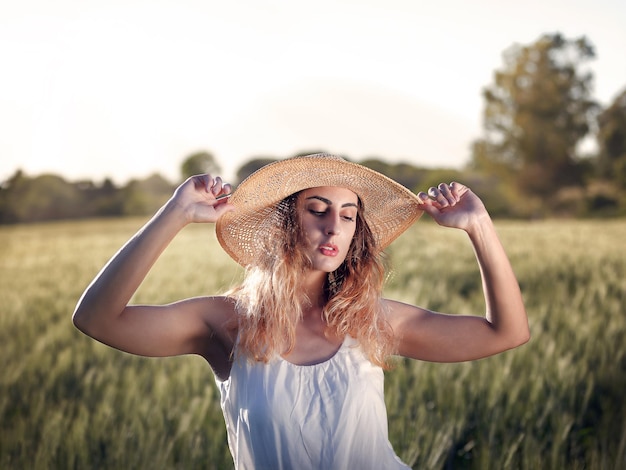 Retrato de uma jovem de pé no campo contra o céu