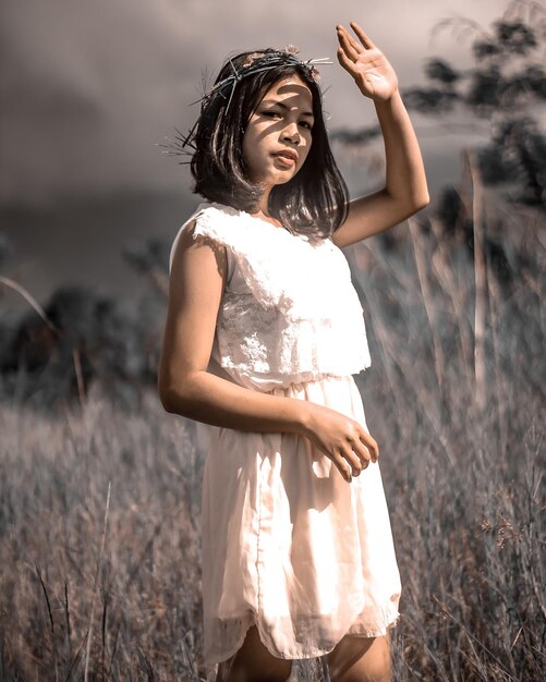 Foto retrato de uma jovem de pé no campo
