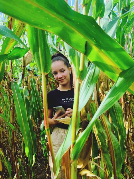 Foto retrato de uma jovem de pé no meio de plantas