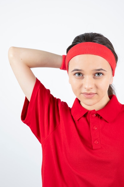 Retrato de uma jovem desportiva em pé e a posar numa parede branca