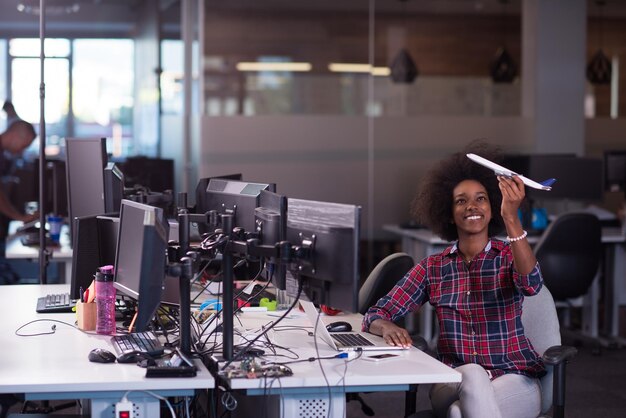 retrato de uma jovem e bela mulher afro-americana de sucesso que gosta de passar um tempo alegre e de qualidade enquanto trabalha em um grande escritório moderno