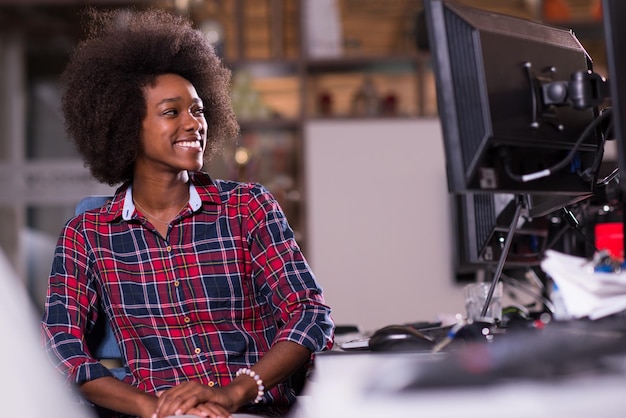 retrato de uma jovem e bela mulher afro-americana de sucesso que gosta de passar um tempo alegre e de qualidade enquanto trabalha em um grande escritório moderno