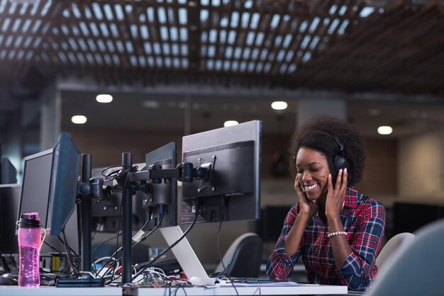 retrato de uma jovem e bela mulher afro-americana de sucesso que gosta de passar um tempo alegre e de qualidade enquanto trabalha em um grande escritório moderno